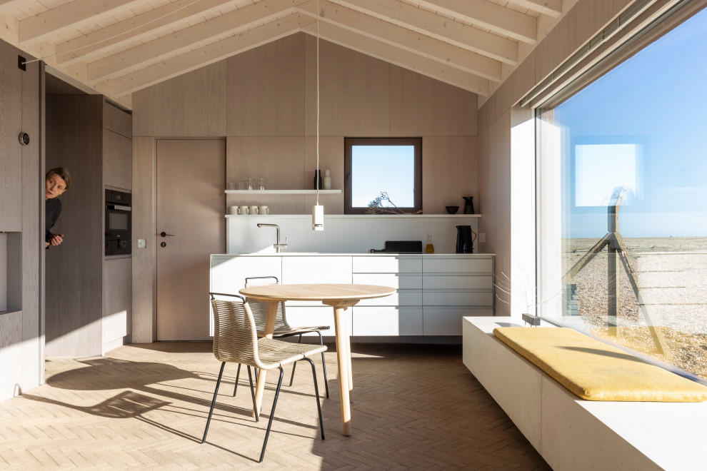 Foto di una cucina stile marinaro con ante lisce, ante bianche, nessuna isola, pavimento beige, top bianco, travi a vista, soffitto a volta e soffitto in legno