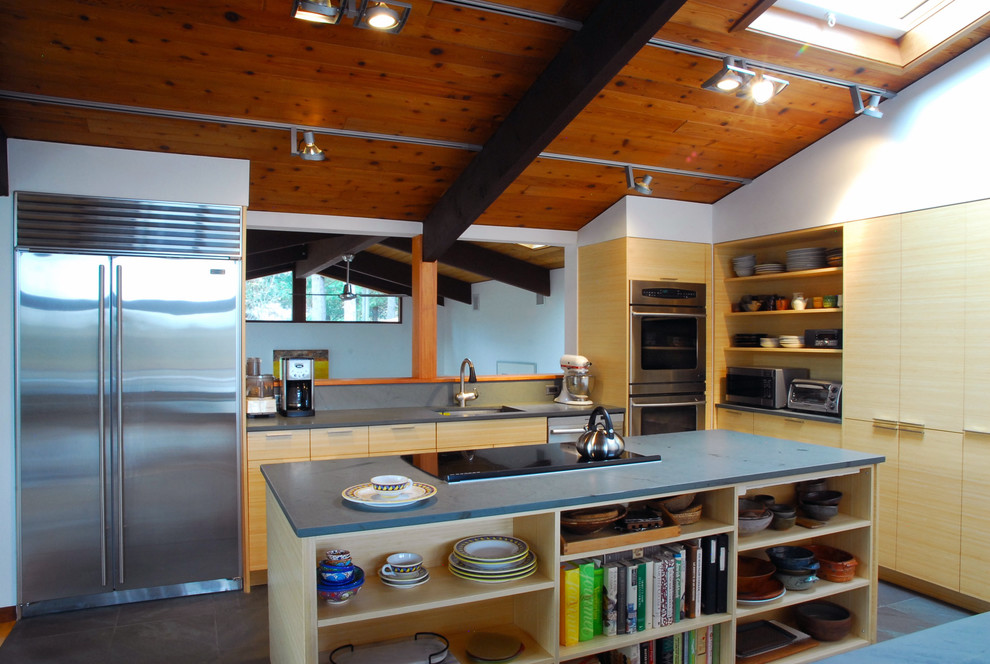 Foto de cocina minimalista con electrodomésticos de acero inoxidable, armarios abiertos y puertas de armario de madera clara