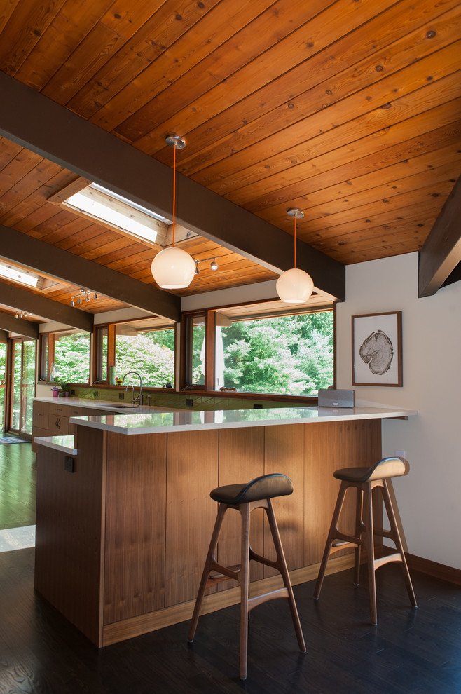 Inspiration for a 1950s dark wood floor and brown floor kitchen remodel in Wilmington with an undermount sink, flat-panel cabinets, quartz countertops, green backsplash, stainless steel appliances, a peninsula and white countertops