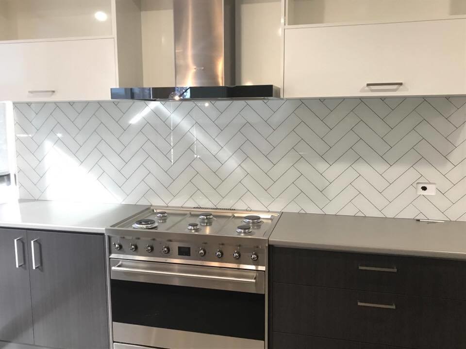 Moderne Küche mit Unterbauwaschbecken, Küchenrückwand in Weiß, Glasrückwand, Küchengeräten aus Edelstahl und Kücheninsel in Sydney