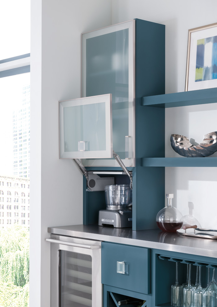 Aménagement d'une cuisine américaine moderne de taille moyenne avec un placard à porte plane, des portes de placard bleues, un électroménager en acier inoxydable, îlot et un sol gris.
