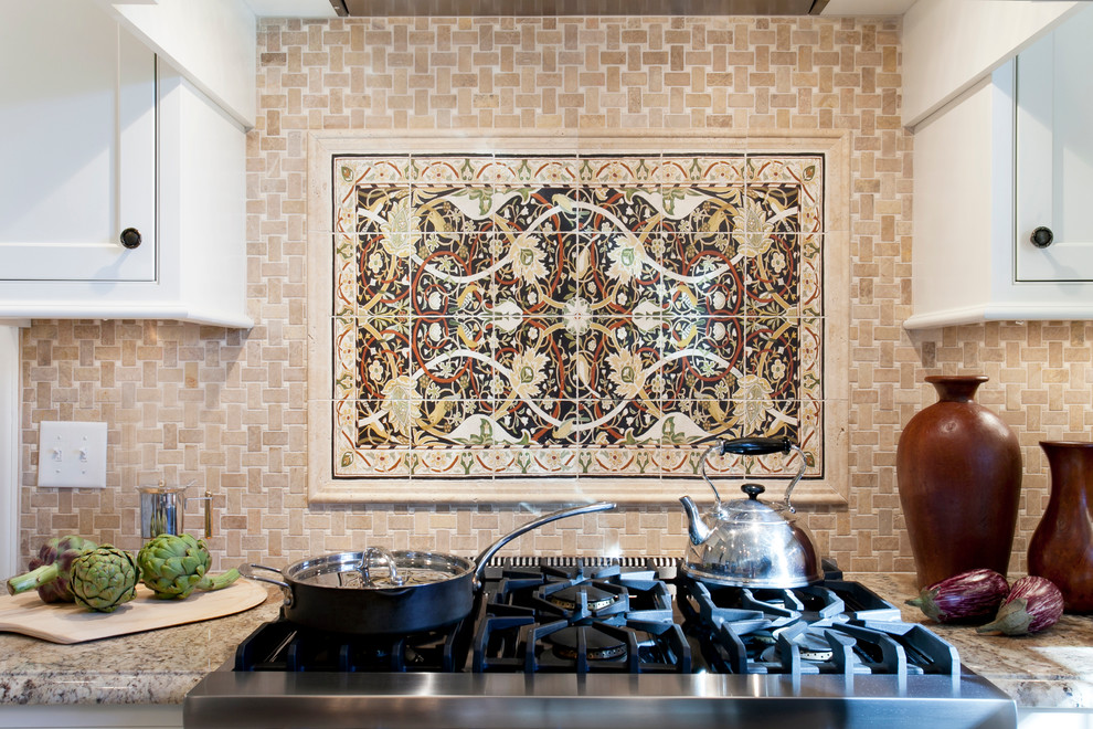 Esempio di una cucina ad U mediterranea chiusa con lavello sottopiano, ante di vetro, ante bianche, top in granito, paraspruzzi beige e elettrodomestici da incasso