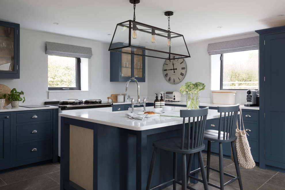 Immagine di una cucina country con lavello stile country, ante in stile shaker, ante blu, pavimento grigio e top bianco
