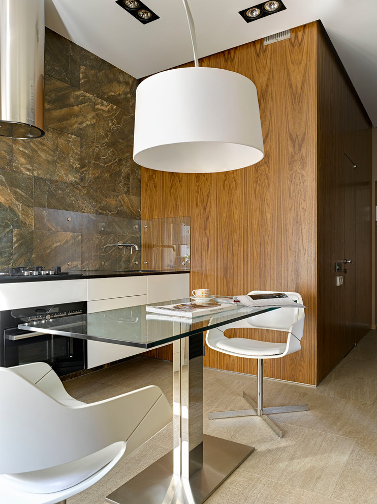 Modern inredning av ett linjärt kök och matrum, med släta luckor, vita skåp, brunt stänkskydd, glaspanel som stänkskydd, svarta vitvaror och beiget golv