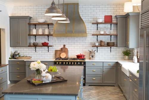Modern kitchen with gray RTA cabinets, brass hardware, subway tile backsplash, and open wood shelving