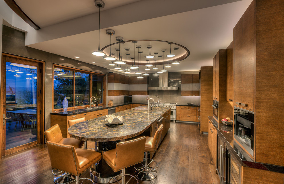 Moderne Küche mit flächenbündigen Schrankfronten, braunen Schränken, Küchenrückwand in Grau, Küchengeräten aus Edelstahl, dunklem Holzboden, Kücheninsel und braunem Boden in Salt Lake City