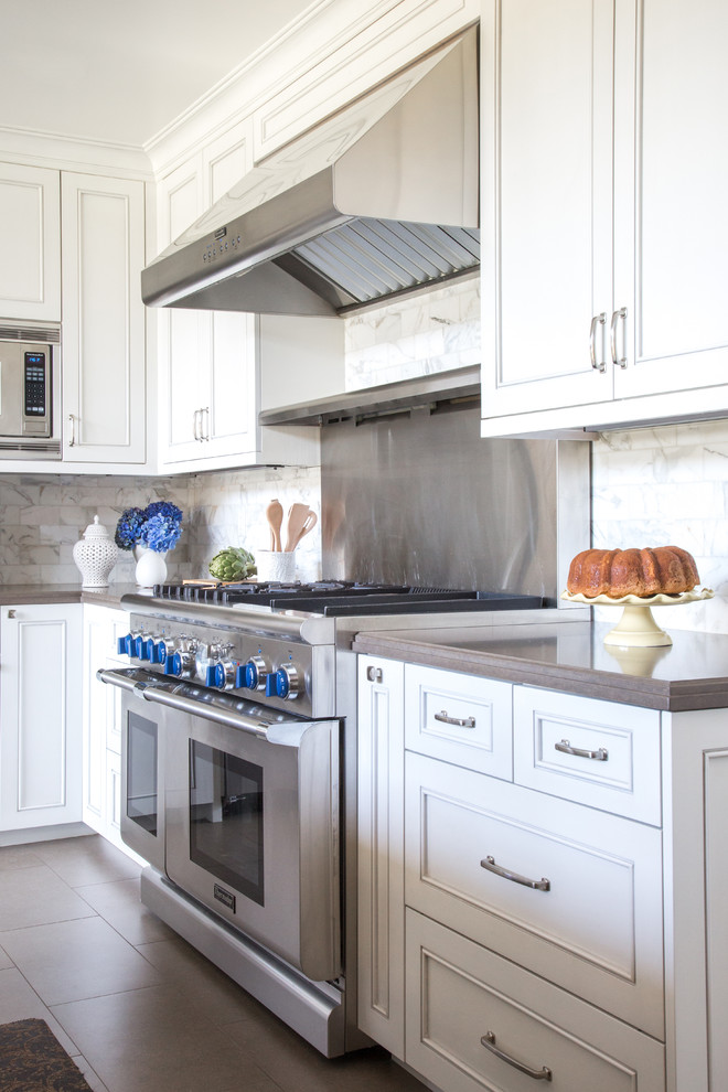 Exempel på ett mellanstort klassiskt kök, med en undermonterad diskho, skåp i shakerstil, vita skåp, bänkskiva i kvarts, vitt stänkskydd, stänkskydd i stenkakel, rostfria vitvaror och en köksö
