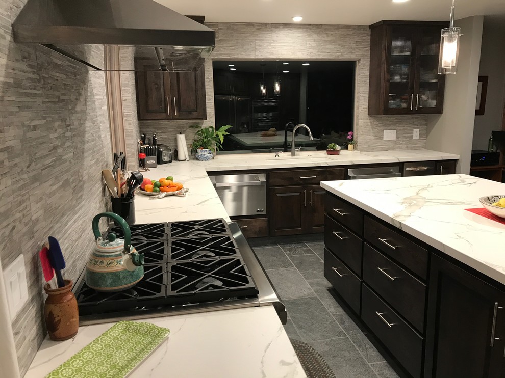 Esempio di una grande cucina minimal con lavello sottopiano, top in superficie solida e elettrodomestici in acciaio inossidabile