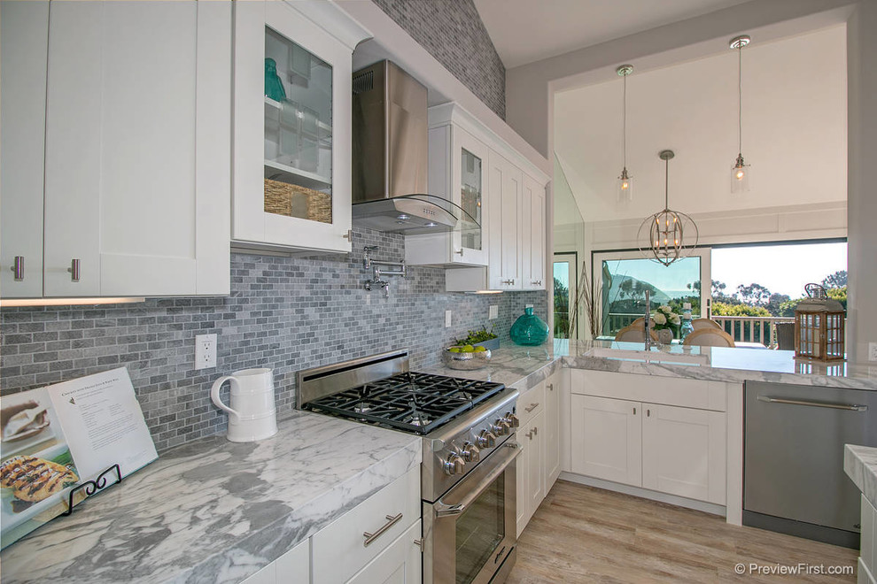Photo of a large contemporary u-shaped kitchen/diner in San Diego with a submerged sink, shaker cabinets, white cabinets, granite worktops, grey splashback, stone tiled splashback, stainless steel appliances, porcelain flooring and a breakfast bar.