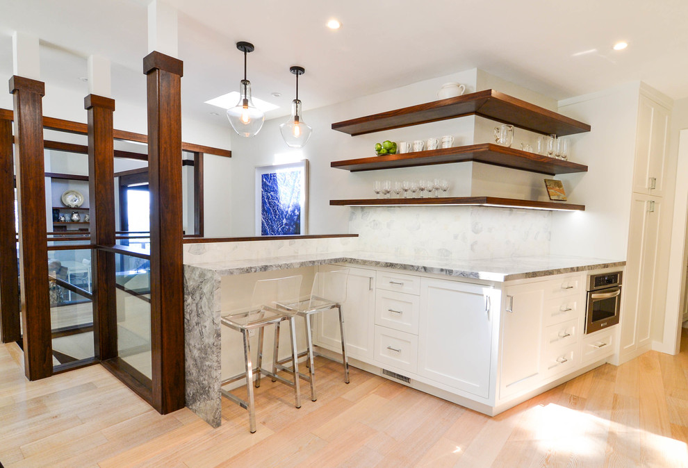 Modern inredning av ett mellanstort kök, med en enkel diskho, skåp i shakerstil, vita skåp, bänkskiva i kvartsit, vitt stänkskydd, stänkskydd i stenkakel, rostfria vitvaror och mellanmörkt trägolv