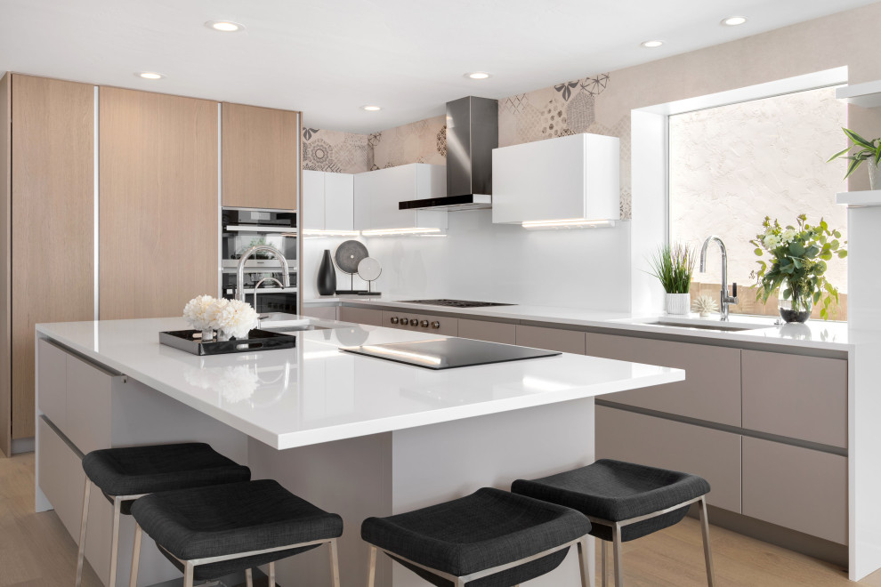Inspiration for a large contemporary l-shaped light wood floor kitchen remodel in Tampa with an undermount sink, flat-panel cabinets, gray cabinets, quartz countertops, black appliances, an island, white countertops and white backsplash