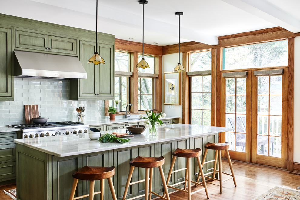 Mid-sized arts and crafts single-wall medium tone wood floor and brown floor open concept kitchen photo in DC Metro with an undermount sink, recessed-panel cabinets, green cabinets, quartz countertops, green backsplash, glass tile backsplash, paneled appliances, an island and gray countertops
