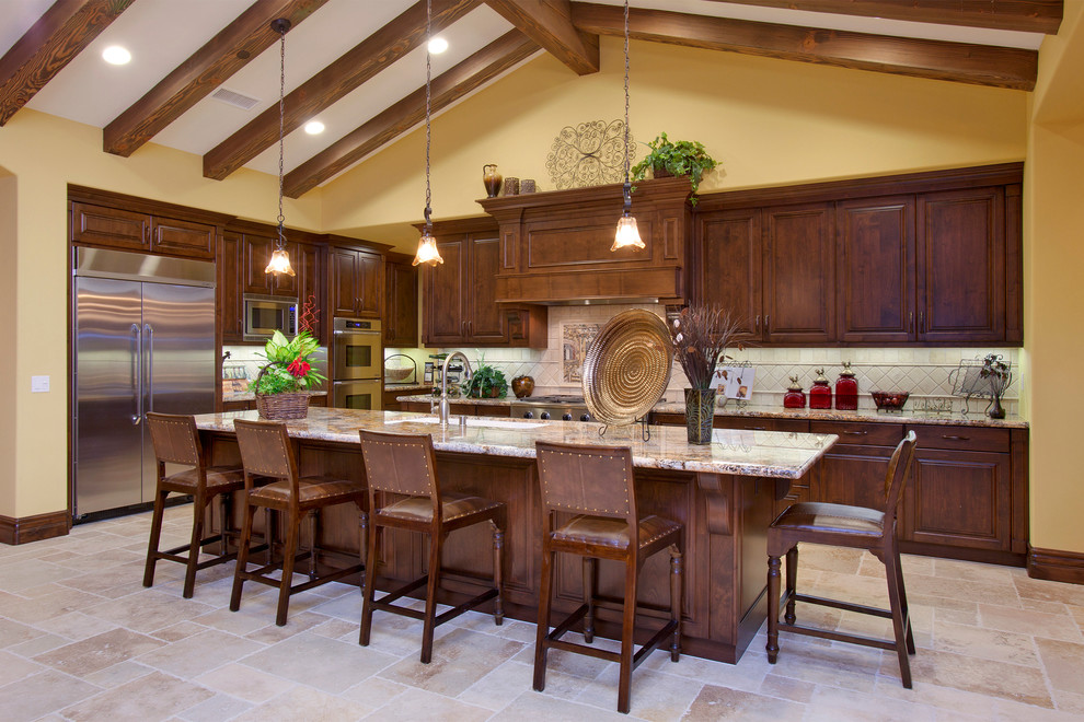 Bild på ett medelhavsstil kök, med en undermonterad diskho, luckor med upphöjd panel, skåp i mellenmörkt trä, granitbänkskiva, beige stänkskydd och rostfria vitvaror