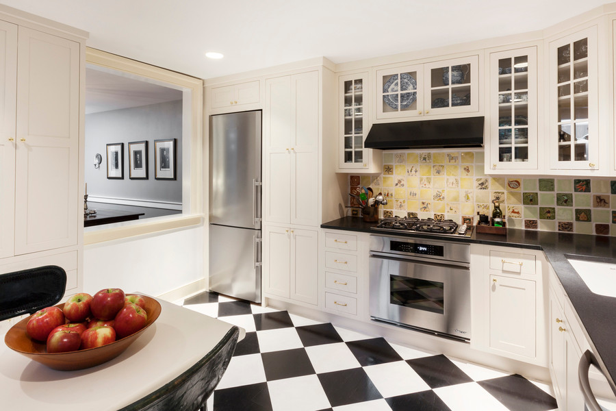 Exempel på ett avskilt, mellanstort klassiskt l-kök, med en undermonterad diskho, luckor med profilerade fronter, vita skåp, granitbänkskiva, flerfärgad stänkskydd, stänkskydd i keramik, rostfria vitvaror och målat trägolv