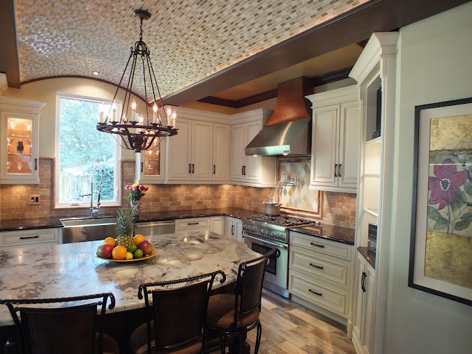 Inredning av ett klassiskt kök, med en rustik diskho, luckor med upphöjd panel, vita skåp, granitbänkskiva, beige stänkskydd, stänkskydd i stenkakel och rostfria vitvaror