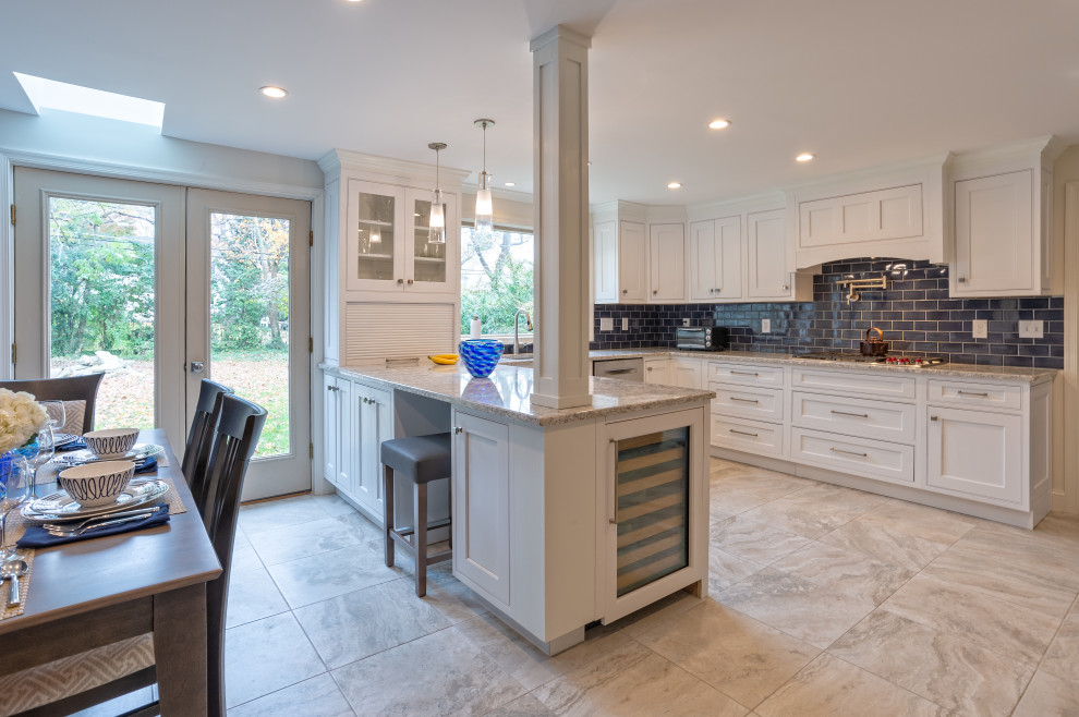 Inspiration for a large transitional u-shaped porcelain tile and gray floor eat-in kitchen remodel in Philadelphia with a drop-in sink, shaker cabinets, white cabinets, quartz countertops, blue backsplash, porcelain backsplash, stainless steel appliances, a peninsula and white countertops