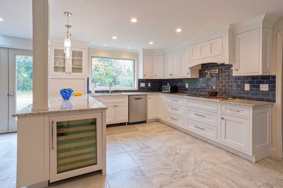 Large transitional u-shaped porcelain tile and gray floor eat-in kitchen photo in Philadelphia with a drop-in sink, shaker cabinets, white cabinets, quartz countertops, blue backsplash, porcelain backsplash, stainless steel appliances, a peninsula and white countertops