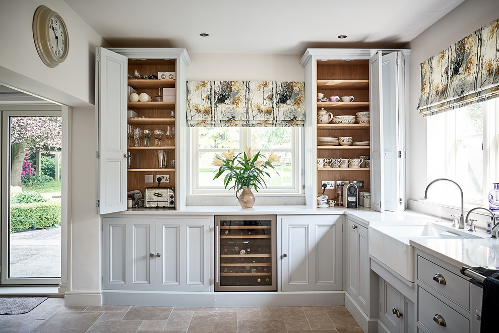 Cette image montre une petite cuisine design avec un placard avec porte à panneau encastré, des portes de placard grises, un plan de travail en quartz et un plan de travail blanc.