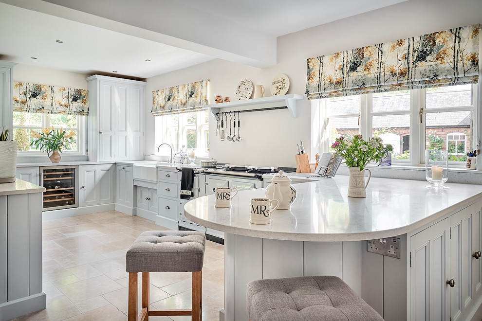 Exempel på ett lantligt vit vitt u-kök, med luckor med infälld panel, grå skåp, bänkskiva i kvartsit, en rustik diskho, en halv köksö och beiget golv