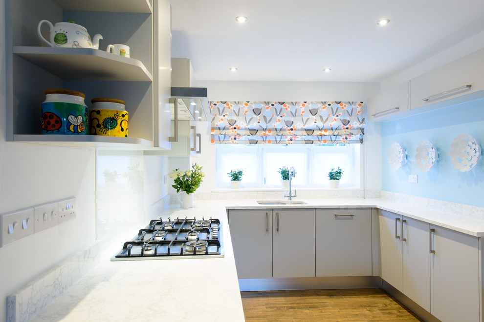 Foto di una cucina moderna di medie dimensioni con lavello sottopiano, ante lisce, ante grigie, top in quarzite, elettrodomestici in acciaio inossidabile, pavimento in gres porcellanato e penisola