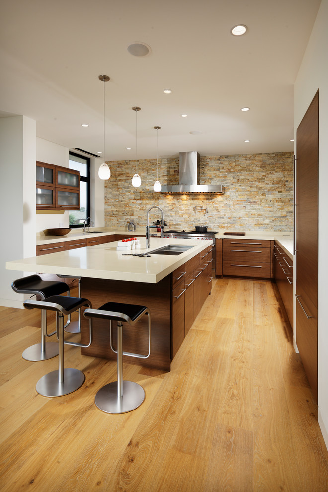 Bild på ett mellanstort funkis kök, med en undermonterad diskho, släta luckor, skåp i mörkt trä, beige stänkskydd, stänkskydd i stenkakel, integrerade vitvaror, en köksö, ljust trägolv och beiget golv