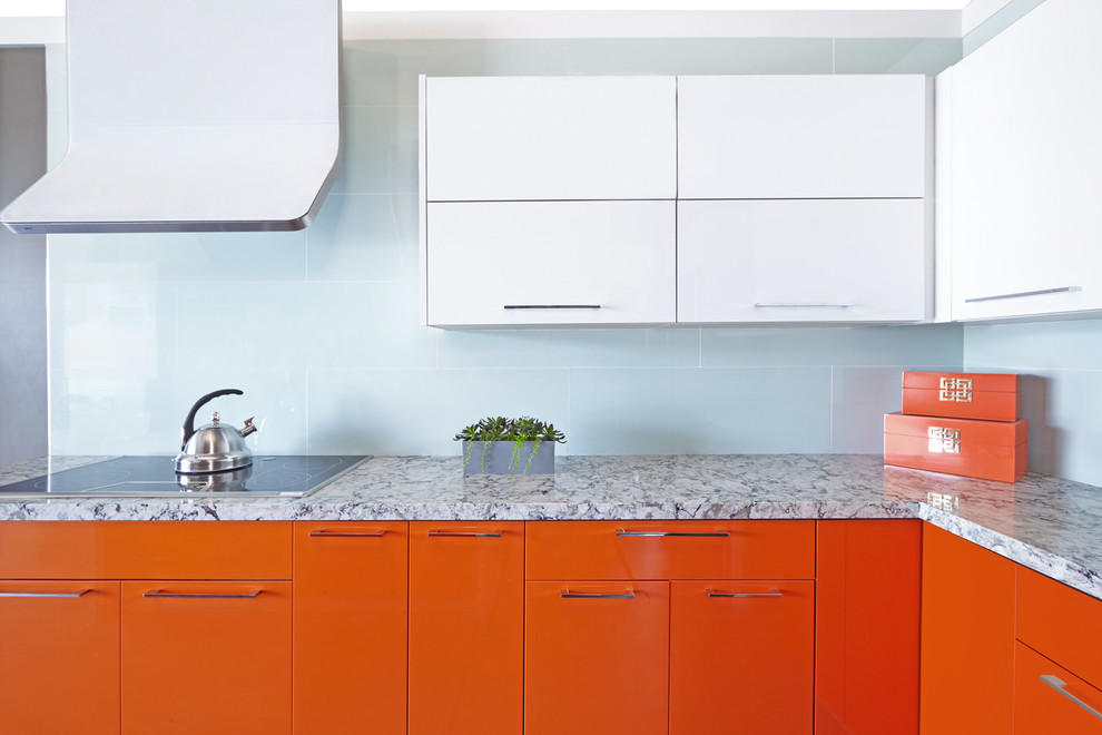 Foto på ett mellanstort funkis kök, med en nedsänkt diskho, släta luckor, orange skåp, marmorbänkskiva, blått stänkskydd, rostfria vitvaror och en köksö