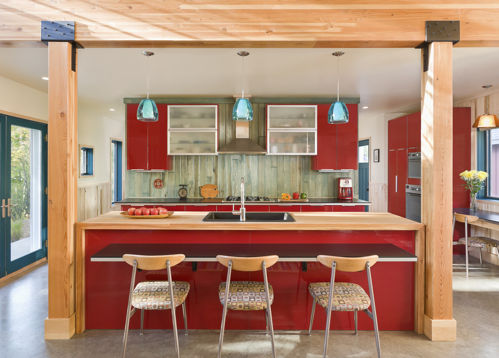 Design ideas for a rustic galley open plan kitchen in Minneapolis with flat-panel cabinets, red cabinets, concrete flooring and a built-in sink.