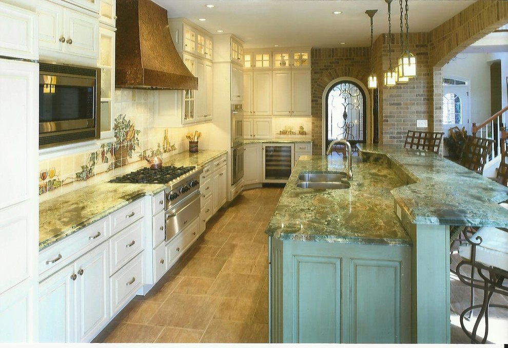 Klassische Wohnküche in L-Form mit Unterbauwaschbecken, profilierten Schrankfronten, weißen Schränken, Granit-Arbeitsplatte, Rückwand aus Mosaikfliesen und Küchengeräten aus Edelstahl in Sonstige