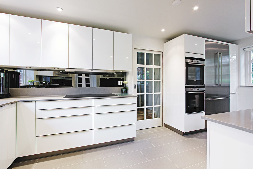 Cette image montre une cuisine design avec un électroménager en acier inoxydable et un sol gris.
