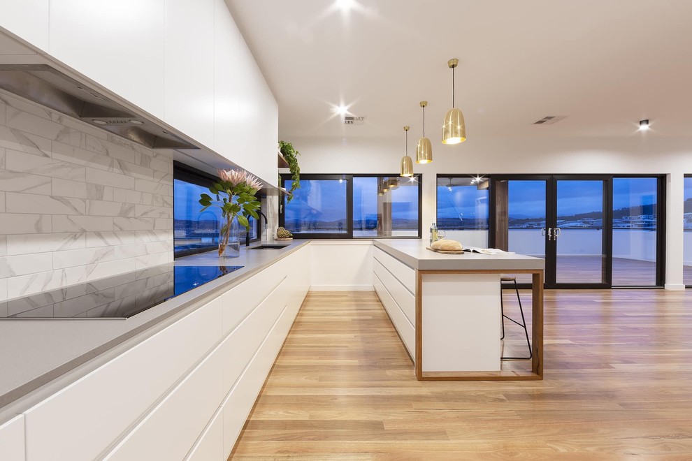 Foto di una cucina minimalista di medie dimensioni con paraspruzzi con piastrelle in ceramica e pavimento in legno massello medio