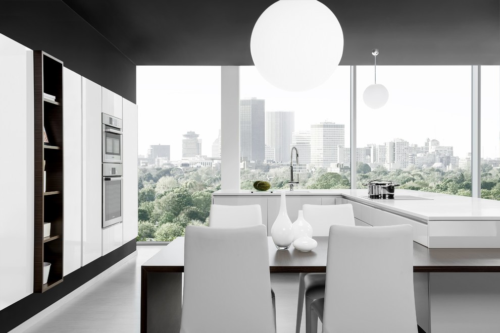 Große Moderne Küche mit flächenbündigen Schrankfronten, weißen Schränken, Küchengeräten aus Edelstahl und Halbinsel in New York