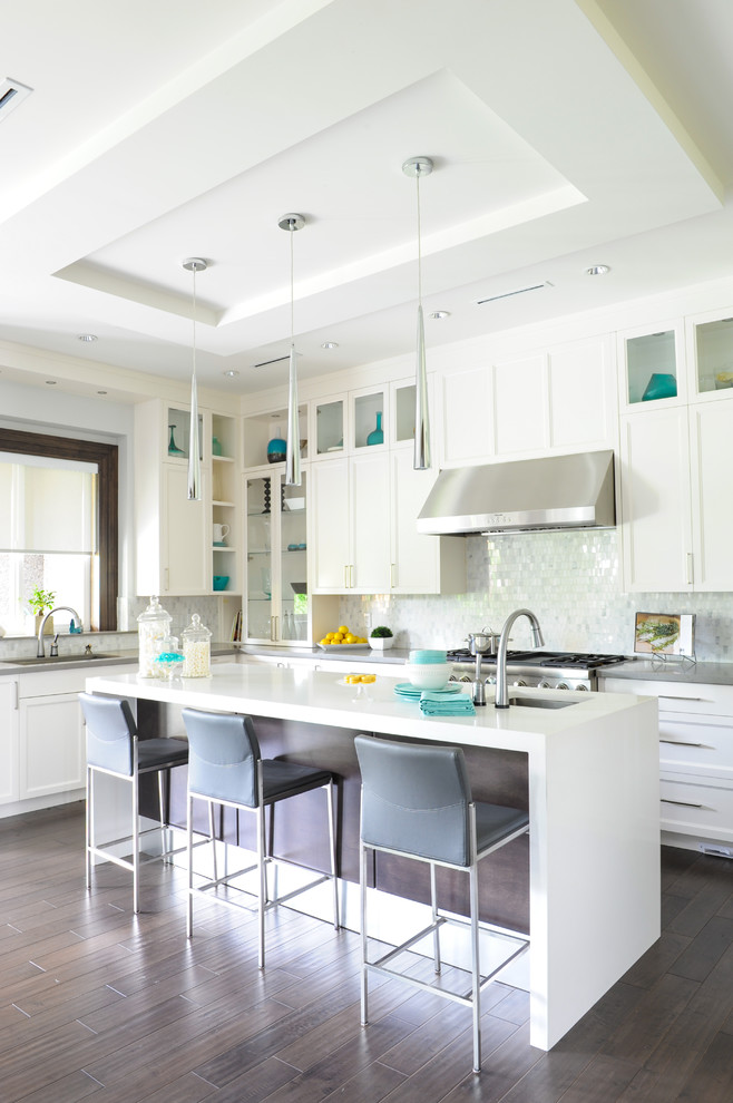 Large classic l-shaped kitchen in Vancouver with shaker cabinets, white cabinets, mosaic tiled splashback, stainless steel appliances, dark hardwood flooring, an island and brown floors.