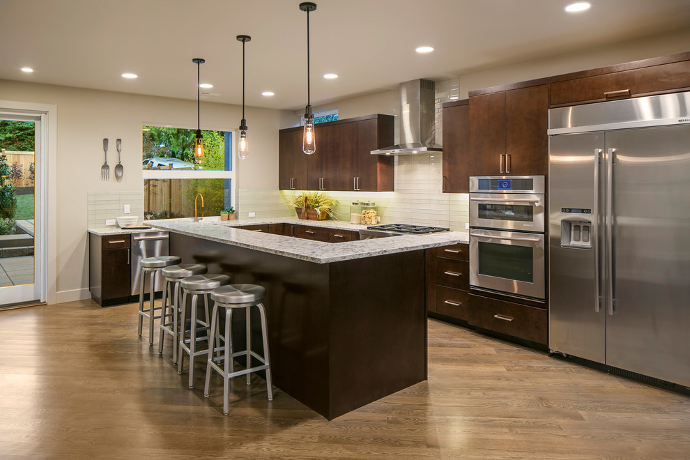 Eat-in kitchen - large contemporary l-shaped light wood floor and brown floor eat-in kitchen idea in Seattle with flat-panel cabinets, dark wood cabinets, granite countertops, white backsplash, glass tile backsplash, stainless steel appliances, an island and gray countertops