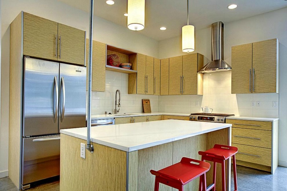 Idéer för ett mellanstort modernt kök, med rostfria vitvaror, en undermonterad diskho, släta luckor, skåp i ljust trä, bänkskiva i kvarts, vitt stänkskydd, stänkskydd i porslinskakel, betonggolv och en köksö