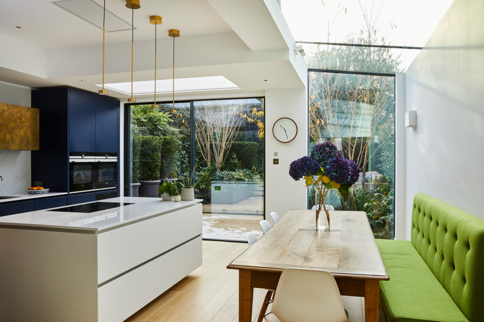 Offene, Einzeilige, Mittelgroße Moderne Küche mit blauen Schränken, Marmor-Arbeitsplatte, Küchenrückwand in Weiß, Rückwand aus Marmor, Kücheninsel und weißer Arbeitsplatte in Surrey