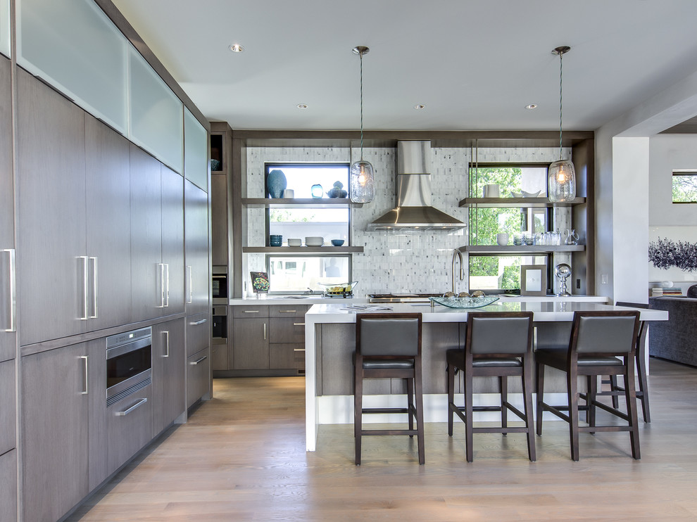 Inspiration for a contemporary open plan kitchen in Denver with flat-panel cabinets, dark wood cabinets, grey splashback and stainless steel appliances.