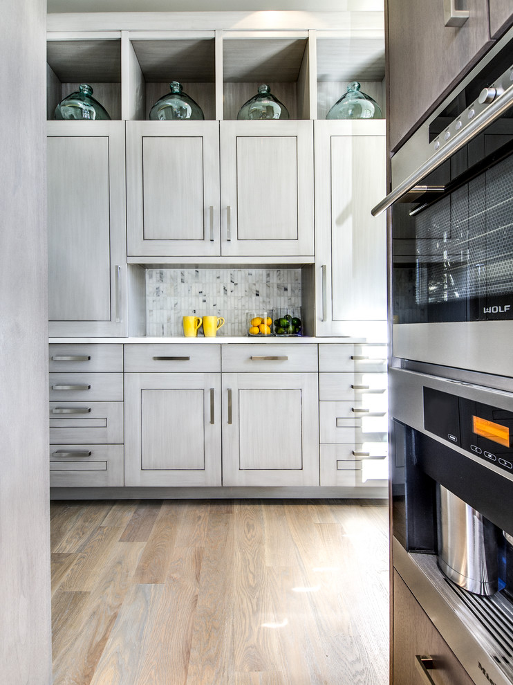 Moderne Küche mit flächenbündigen Schrankfronten, grauen Schränken, Küchenrückwand in Grau und Küchengeräten aus Edelstahl in Denver