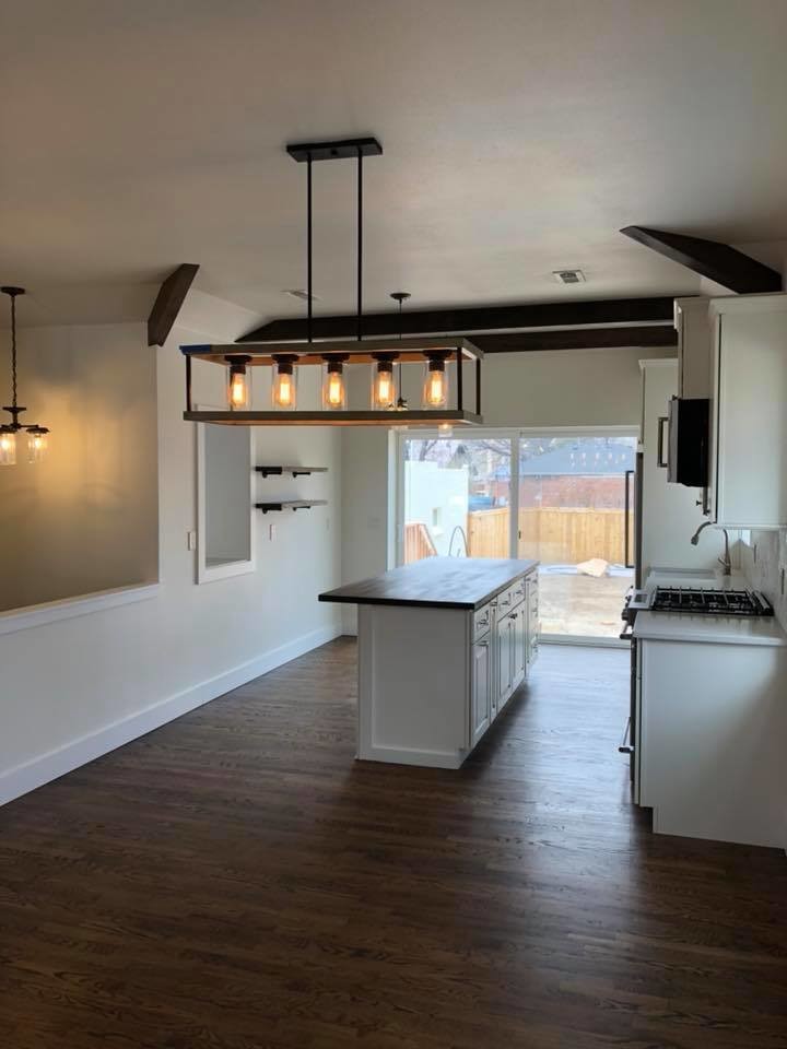 Inspiration for a large cottage single-wall dark wood floor and brown floor eat-in kitchen remodel in Denver with a farmhouse sink, raised-panel cabinets, white cabinets, wood countertops, gray backsplash, ceramic backsplash, stainless steel appliances, an island and brown countertops