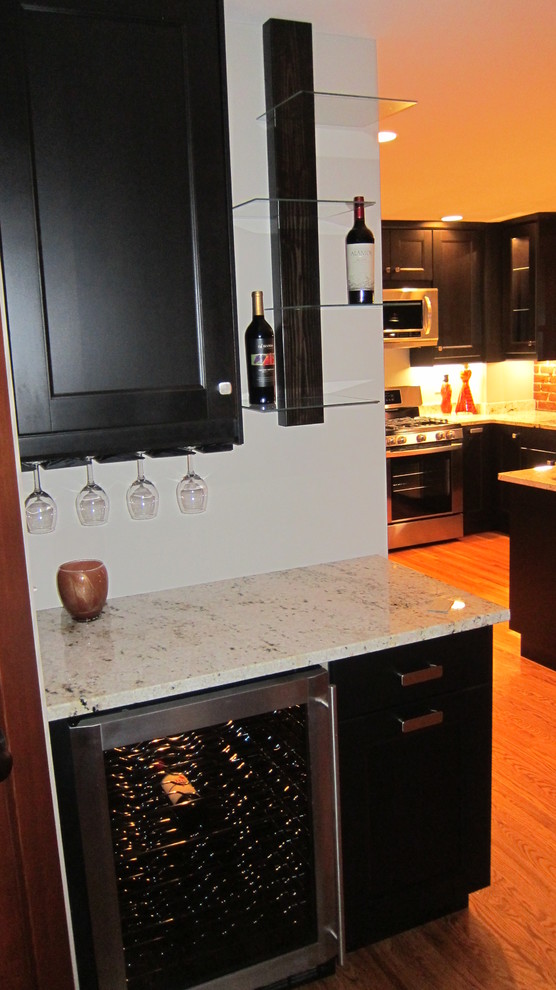 Exempel på ett mellanstort eklektiskt kök och matrum, med skåp i shakerstil, svarta skåp, rött stänkskydd, stänkskydd i tegel, rostfria vitvaror, ljust trägolv, en halv köksö och brunt golv