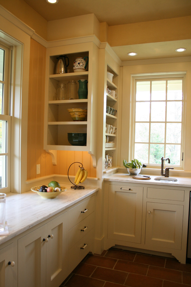 Idéer för ett klassiskt kök, med marmorbänkskiva, en undermonterad diskho, luckor med infälld panel och gula skåp