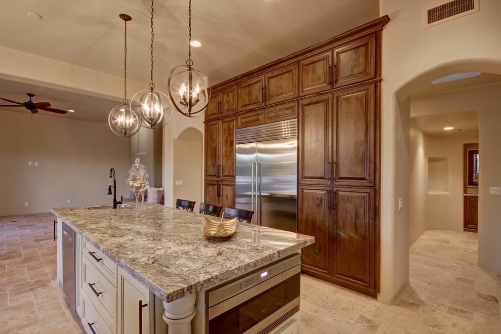 Example of a huge southwest u-shaped travertine floor open concept kitchen design in Phoenix with an undermount sink, recessed-panel cabinets, dark wood cabinets, granite countertops, gray backsplash, glass tile backsplash, stainless steel appliances and an island