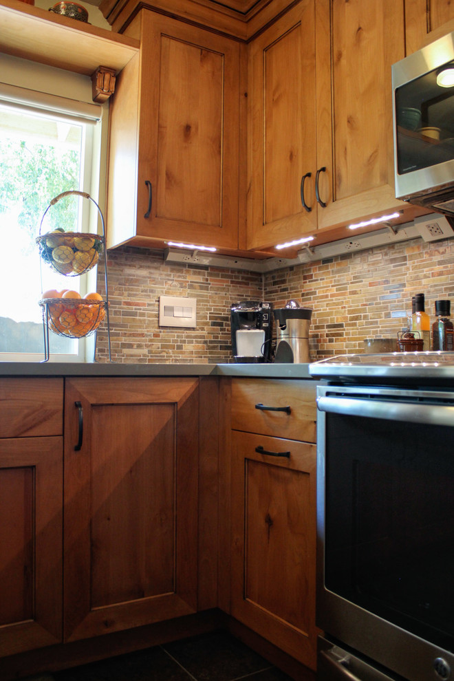 Inredning av ett amerikanskt mellanstort kök, med en enkel diskho, luckor med infälld panel, skåp i mellenmörkt trä, bänkskiva i kvarts, flerfärgad stänkskydd, stänkskydd i stenkakel, integrerade vitvaror och klinkergolv i porslin
