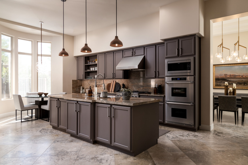 Example of a trendy galley gray floor kitchen design in Phoenix with recessed-panel cabinets, brown cabinets, brown backsplash, stone slab backsplash, stainless steel appliances, an island and brown countertops