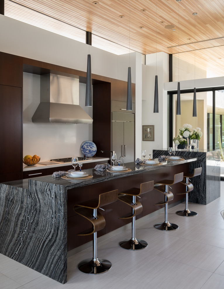 フェニックスにあるサンタフェスタイルのおしゃれなキッチン (フラットパネル扉のキャビネット、濃色木目調キャビネット、白いキッチンパネル、パネルと同色の調理設備、グレーの床) の写真