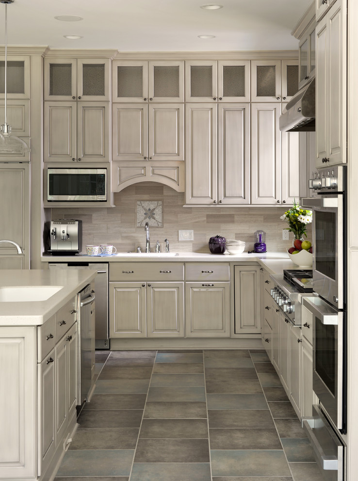 Klassische Küche mit profilierten Schrankfronten, grauen Schränken, Küchenrückwand in Grau und Kücheninsel in Sonstige