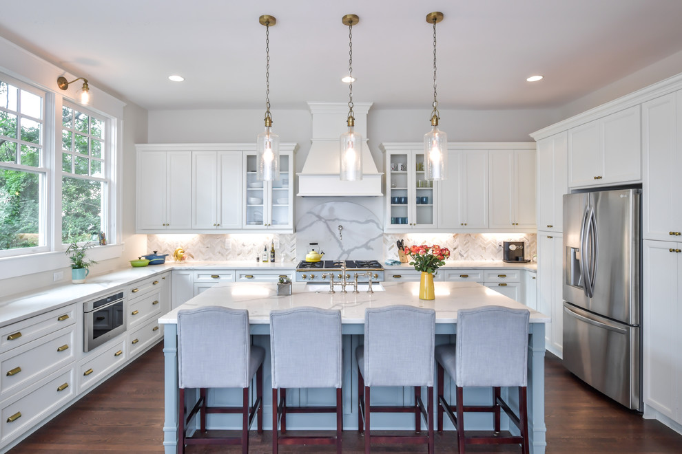 This is an example of a large classic u-shaped kitchen in Atlanta with a belfast sink, shaker cabinets, engineered stone countertops, marble splashback, stainless steel appliances and an island.