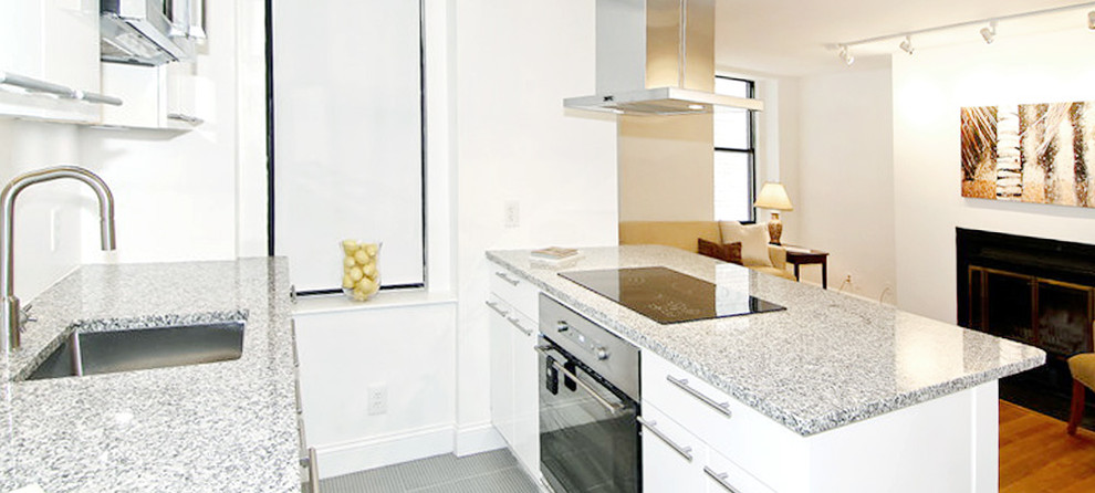 Photo of a small contemporary u-shaped kitchen/diner in DC Metro with a submerged sink, flat-panel cabinets, white cabinets, granite worktops, white splashback, glass sheet splashback, stainless steel appliances, porcelain flooring and a breakfast bar.