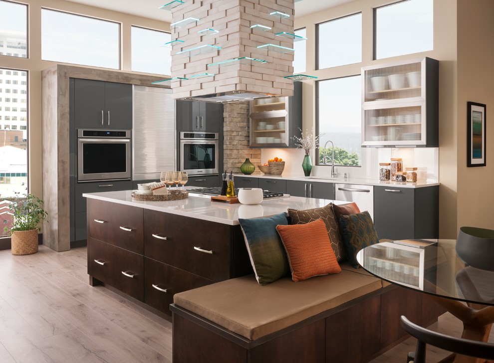 Bild på ett funkis kök, med en undermonterad diskho, släta luckor, grå skåp, fönster som stänkskydd, rostfria vitvaror, ljust trägolv, en köksö och beiget golv