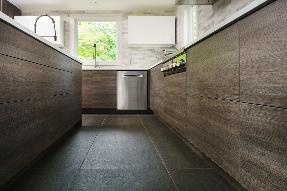 Inredning av ett modernt kök, med släta luckor, grå skåp, en köksö och grått golv