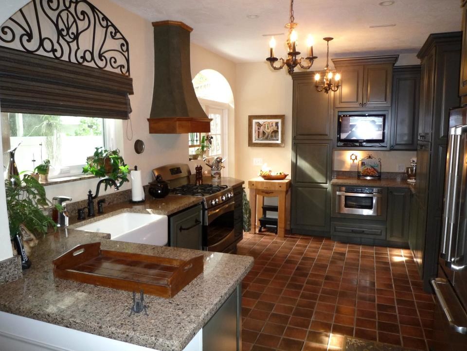 Mid-sized elegant galley terra-cotta tile kitchen photo in Tampa with a farmhouse sink, raised-panel cabinets, green cabinets, quartz countertops and stainless steel appliances